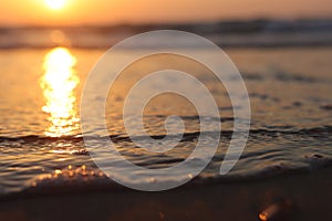 Sea waves and warm sunset light, calm and relaxing sandy beach