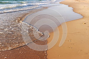 Sea waves and warm sunset light, calm and relaxing sandy beach