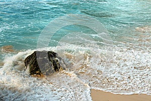 Sea waves and the water splash on the rock background.