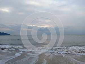 The sea waves were lapping white foam towards the sea beach.