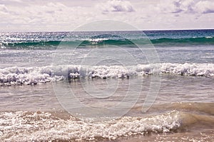 Sea waves. White clouds. Blue water