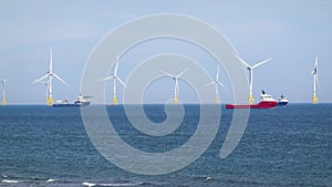 Sea wind farm turbines and ships in Aberdeen, renewable energy. Scotland