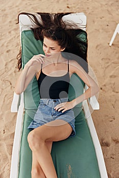 sea woman smiling sand sunbed ocean lying beach resort lifestyle hat