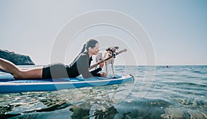 Sea woman sup. Silhouette of happy positive young woman with her dog, surfing on SUP board through calm water surface