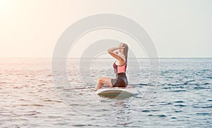 Sea woman sup. Silhouette of happy young woman in pink bikini, surfing on SUP board, confident paddling through water