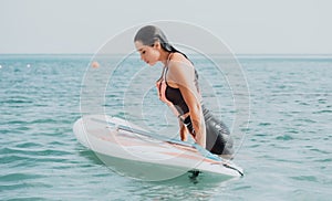 Sea woman sup. Silhouette of happy young woman in pink bikini, surfing on SUP board, confident paddling through water
