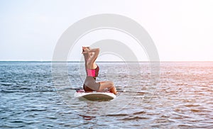 Sea woman sup. Silhouette of happy young woman in pink bikini, surfing on SUP board, confident paddling through water