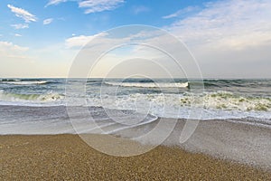 A city beach. A turbulent sea washes footprints in the sand. Benalmadena, Malaga, Andalusia, Spain