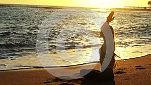 Sea yoga woman hands up in sun salute lotus position