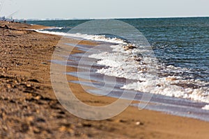 Sea â€‹â€‹waves caress the shore a beautiful landscape and a light breeze froth sea waves the sand and the line of the beach