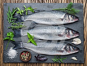 Seabass on a graphite board with spices and herbs.