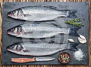 Seabass on a graphite board with spices and herbs.
