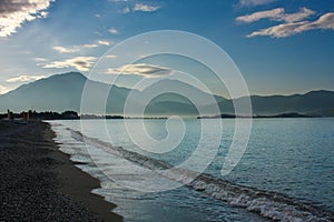 Seacoast on background of mountains and blue sky at dawn