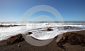Seafoam and seaweed on Moonstone Beach in Cambria on the central coast of California Unted States photo