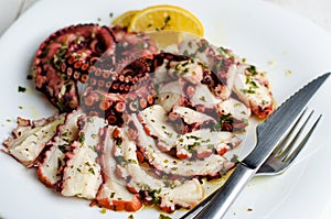 Seafood appetizer. Octopus Carpaccio on white plate. Mediterranean delicacy.