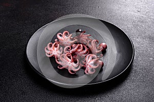 Seafood Baby octopus salad in a black plate
