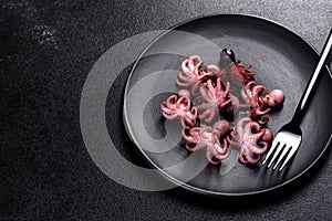 Seafood Baby octopus salad in a black plate