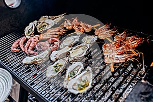 Seafood BBQ  barbecue. Collection of octopus, oysters, clam, tiger shrimps grilled on grill