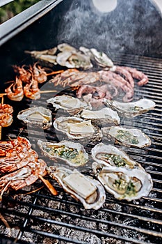 Seafood BBQ  barbecue. Collection of octopus, oysters, clam, tiger shrimps grilled on grill