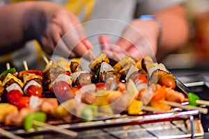 Seafood and beef barbecue BBQ skewered on bamboo sticks with pie apple, tomato, onion and chili are grilling on the stove for ba