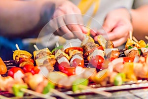 Seafood and beef barbecue BBQ skewered on bamboo sticks with pie apple, tomato, onion and chili are grilling on the stove for ba