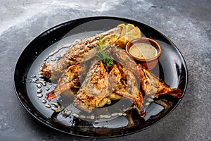 seafood bonanza with dip served in a dish isolated on dark background side view food