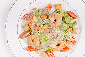 Seafood caesar salad with shrimps, salad leaf, parmesan cheese a