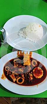 Seafood dinner menu of spicy and sour squid and white rice stimulates the appetite