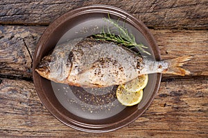 Seafood eating. Grilled fish on plate from above.