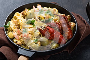 Seafood fettuccine pasta with crayfishes, octopus shrims, on stone pan. Gourmet dish