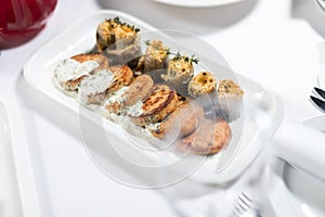 Seafood. Fish cakes and cheese rolls stuffed with fish fillet on a plate on a white background