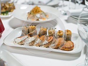 Seafood. Fish cakes and cheese rolls stuffed with fish fillet on a plate on a white background
