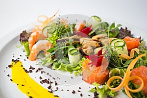 Seafood fresh salad with shrimps, mussels, salmon, green and cucumber