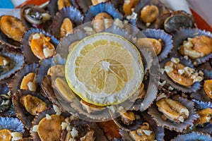 Seafood - grilled limpets served with lemon. Lapas grelhadas