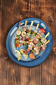 Seafood kebabs on wooden background