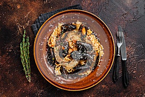 Seafood Mafaldine pasta with mussels and tomato sauce in a rustic plate. Dark background. Top view