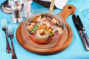 Warm salad of grilled fish pieces, shrimps and mussels in a frying pan