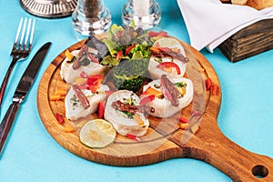 Seafood, Mediterranean cuisine. Vegetable rolls from sea fish with greens, cucumber, lemon and chili. Japanese food