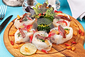 Seafood, Mediterranean cuisine. Vegetable rolls from sea fish with greens, cucumber, lemon and chili. Japanese food