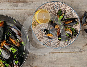 Seafood mussels on a plate with lemon and skillet.and also shrimp on a plate with chili