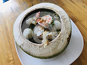 Seafood noodles spicy soup with young coconut meat.