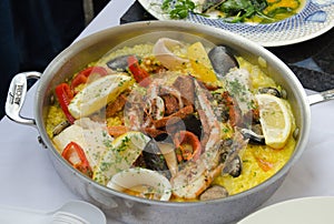 Seafood paella being cooked in a frying pan