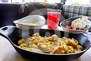 Seafood paella in a cast iron skillet on a wooden table