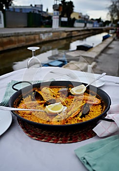 Seafood paella with glass of wine in seaside cafe,Spain