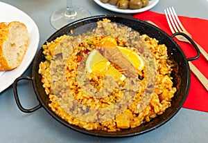 Seafood paella with lemon in pan