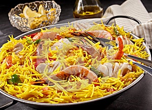 Seafood Paella Meal with Lemon Wedges and Oil