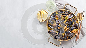 Seafood paella with mussels and shrimps in traditional plate, horizontal, top view, copy space