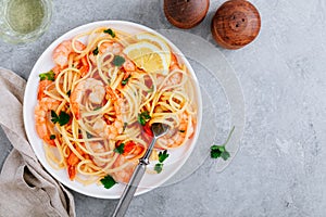 Seafood Pasta spaghetti with shrimps and parsley on gray stone background