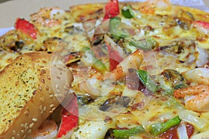 Seafood pizza and garlic bread.