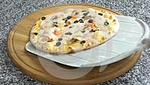 Seafood pizza on wooden board.